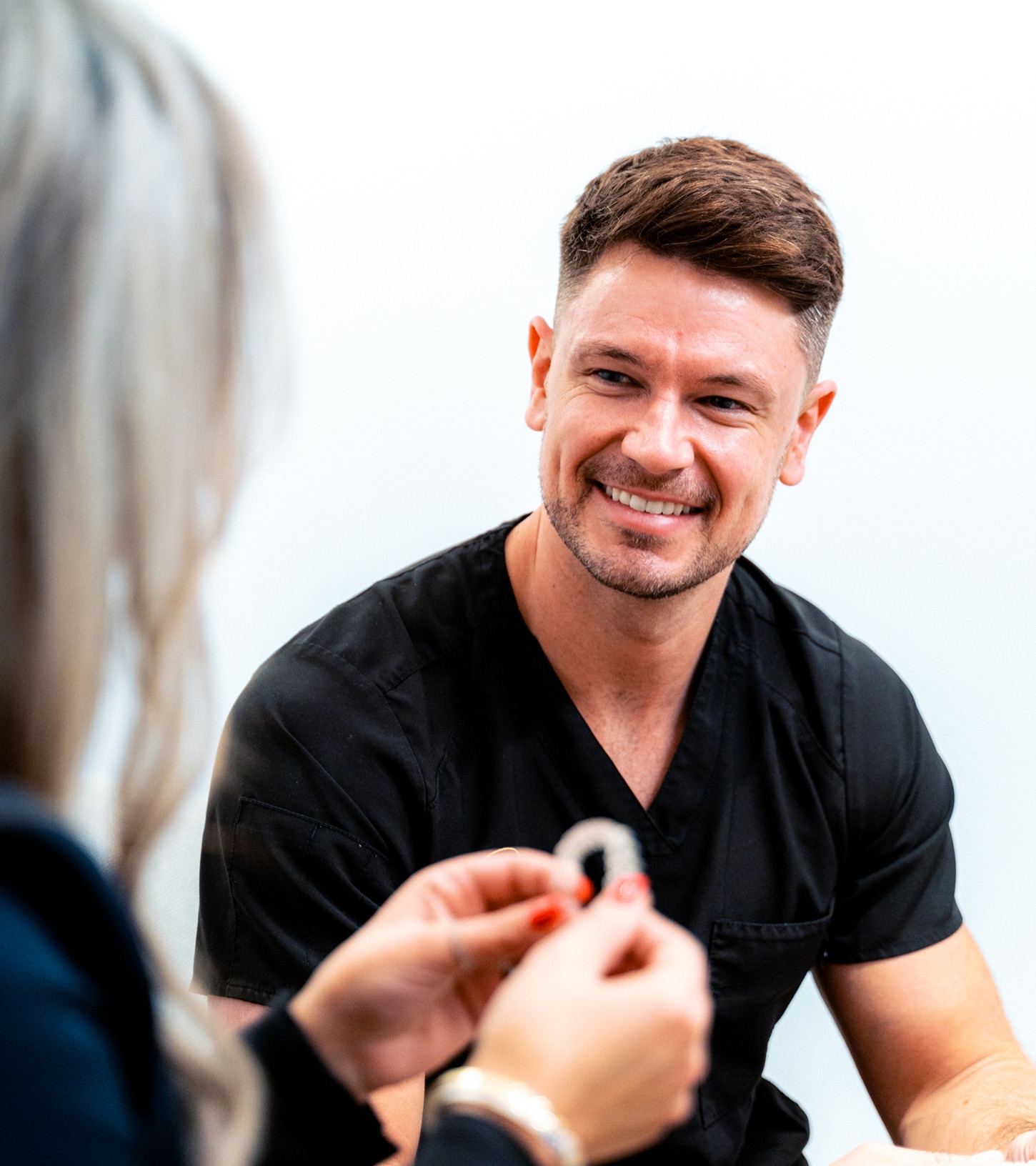 A Spa Dental dentist showing a patient a clear Invisalign aligner